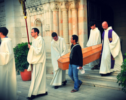 Brüder, Gäste und Renato, der Pfleger von Pater Hieronymus, tragen den Sarg aus der Kirche.