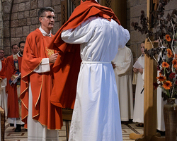 Dechant Matthias Veit, Simeons Heimatpfarrer, hilft, die priesterlichen Gewänder anzulegen.